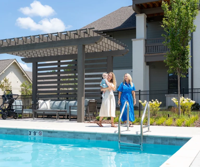 Two women and a child walking around the pool at arise knox square